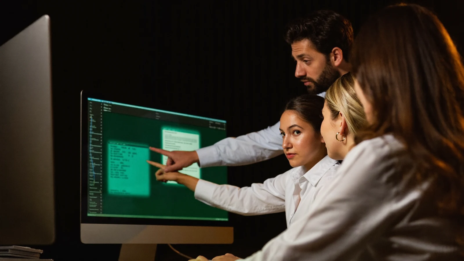 Equipe de atendimento reunida diante do monitor enquanto o gestor aponta um procedimento na fila de conversas