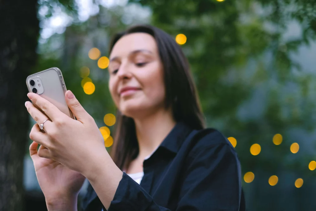 Contador em escritório contábil consultando mensagens de clientes no celular durante atendimento via WhatsApp — gestão de comunicação profissional em 2026