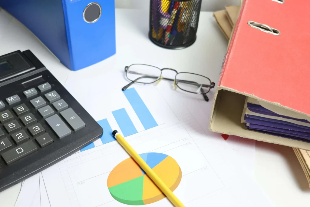 Mesa de escritório contábil com documentos fiscais, calculadora e smartphone aberto — rotina de atendimento manual que pode ser automatizada via WhatsApp contabilidade